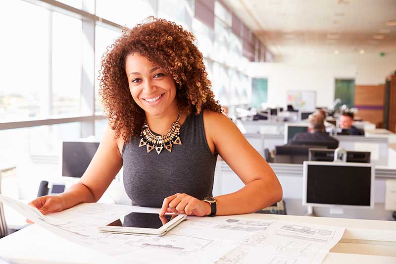 A woman sitting at a table with her cell phone.