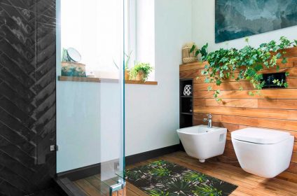 A bathroom with a glass shower door and wooden walls.