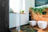 A bathroom with a glass shower door and wooden walls.