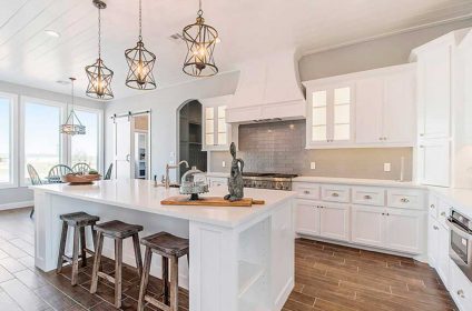 A kitchen with white cabinets and wooden floors