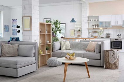 A living room with grey furniture and white walls.