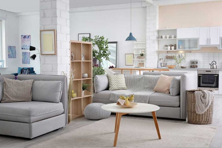 A living room with grey furniture and white walls.