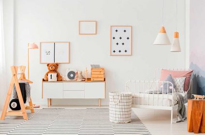A room with a bed, dresser and pictures on the wall.