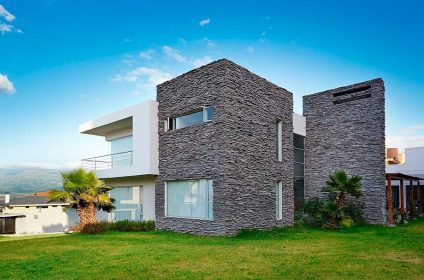 A large modern house with a grassy lawn.