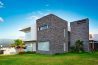 A large modern house with a grassy lawn.